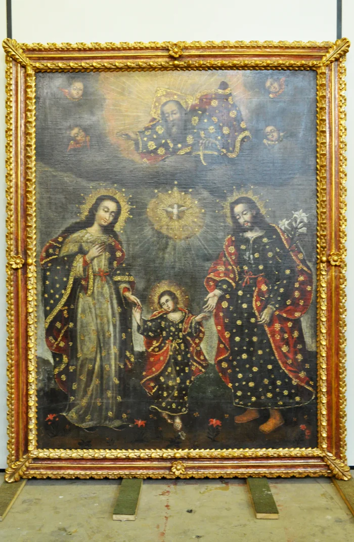 Pintura cusquenha da Sagrada Família com a Santíssima Trindade após a restauração, com o douramento da moldura recuperado e a policromia legível