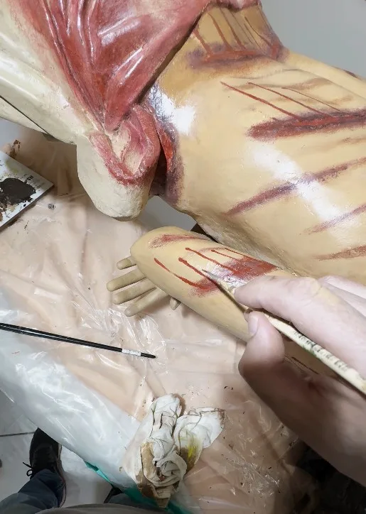 Retoque de restauro em imagem sacra de madeira policromada, feito com pincel fino apenas nas áreas de perda de pintura